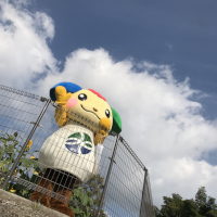 青空の下で手を振るご当地キャラ・みやっきー