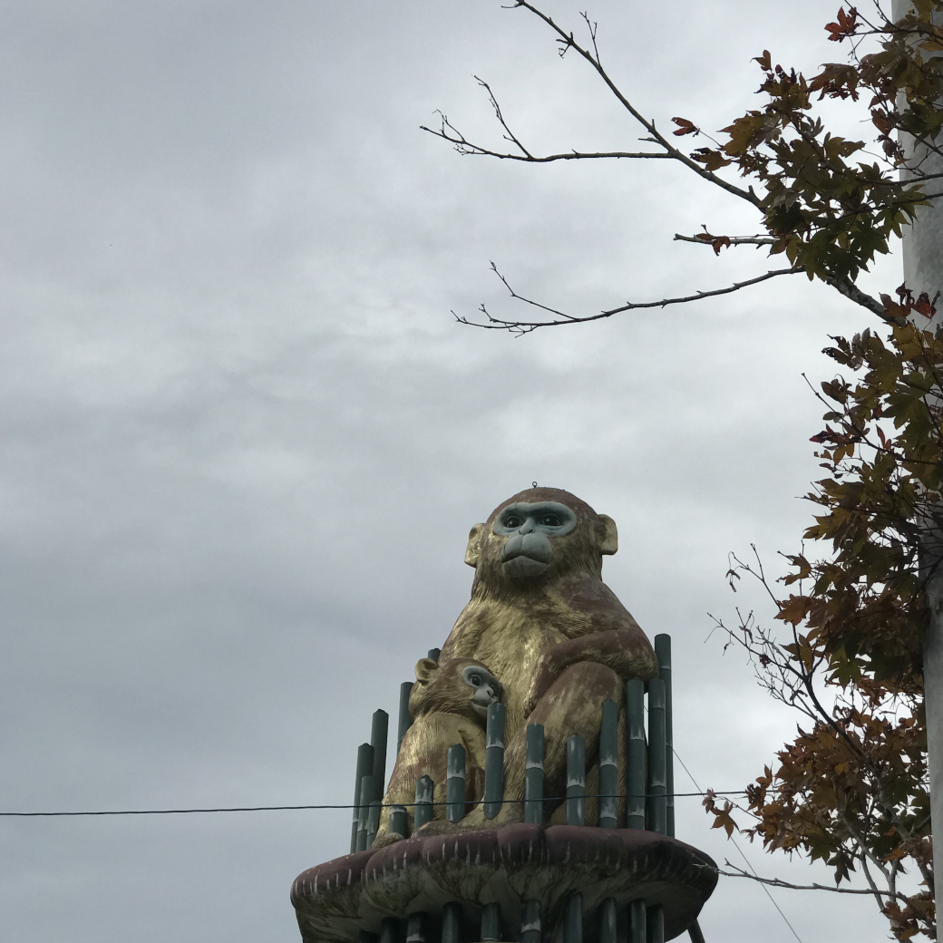 木の上で子猿を抱く母猿のモニュメント